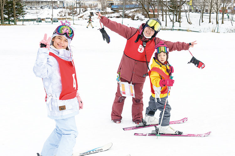 雪の上でピースしている