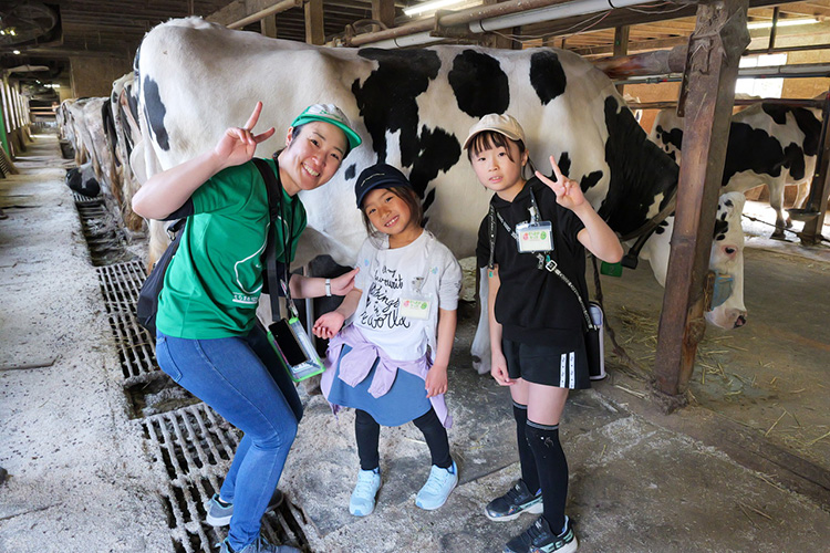 牧場で牛と一緒に写真撮影