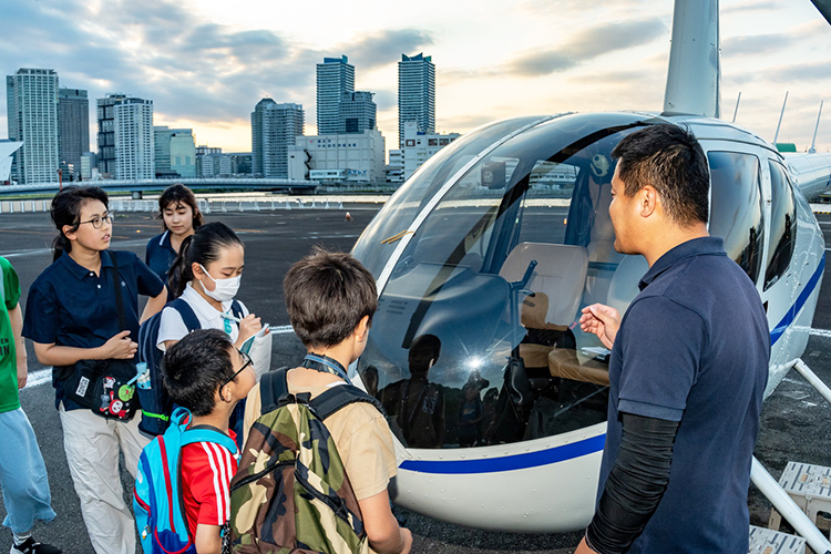 ヘリコプターの前で話を聞く