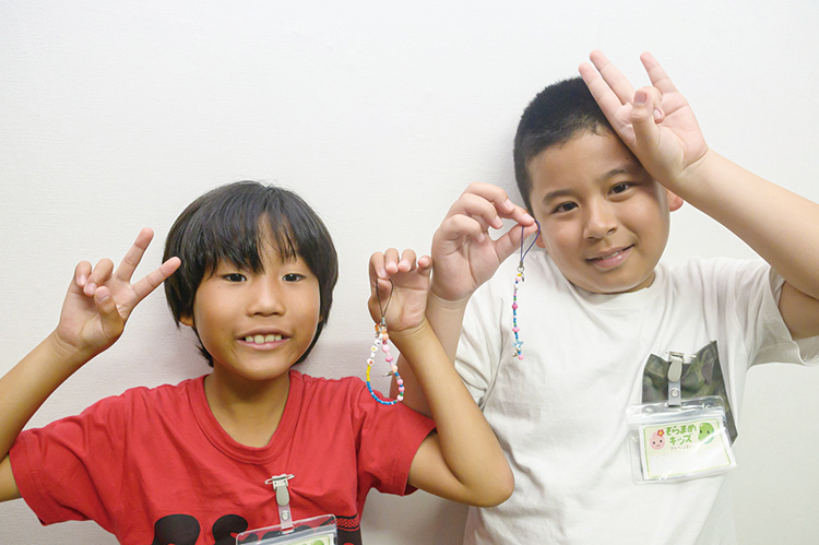 手作りストラップを持つ子ども達